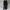 Women's long black double-breasted trench coat styled over a dark top and black trousers, carrying a black handbag.